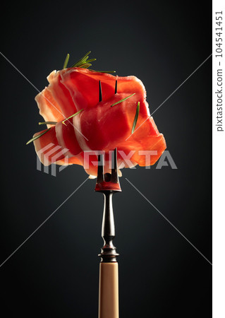 Sliced prosciutto with rosemary. Sliced prosciutto with rosemary. 104541451