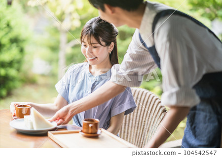 A young woman in a dress and a cafe clerk enjoying coffee at a cafe A young woman in a dress and a cafe clerk enjoying coffee at a cafe 104542547