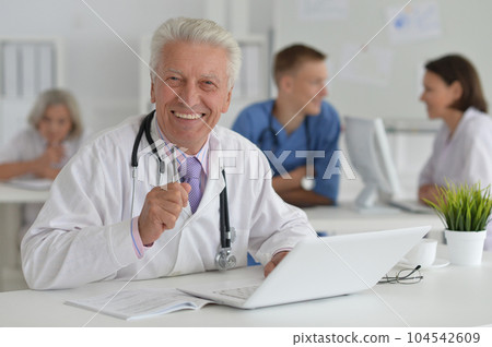Male doctor sitting at table in clinic 104542609