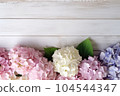Pink, blue and white Hydrangea flowers or Hortensia on white wooden background. Top view. Floral frame banner with copy space. Top view. 104544347