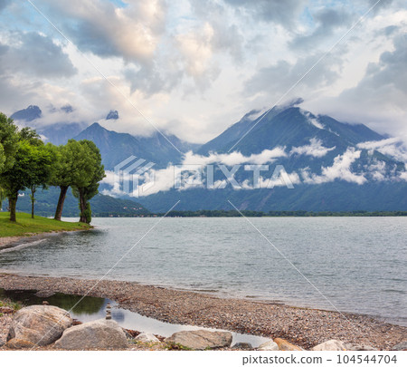 Lake Como (Italy) summer cloudy view with stony shore. 104544704