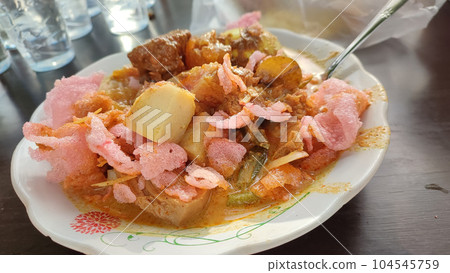 Lontong sayur Padang or Padangnese rice cake spicy soup served on a plate. Lontong sayur Padang or Padangnese rice cake spicy soup served on a plate. 104545759