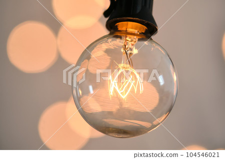 Incandescent light bulb with christmas round bokeh. 104546021