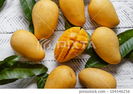 Ripe mangoes on white wood 104546256