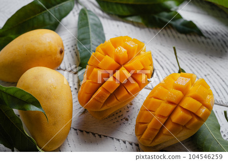 Ripe mangoes on white wood 104546259