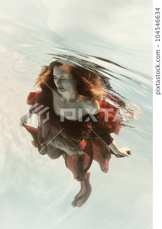 Portrait of a woman in a red dress underwater Portrait of a woman in a red dress underwater 104546634