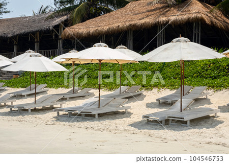 Empty sun loungers on the beach. Beach chairs and umbrellas. Vacation on tropical beach Empty sun loungers on the beach. Beach chairs and umbrellas. Vacation on tropical beach 104546753