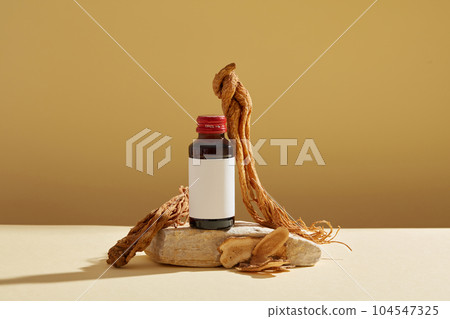 Mockup scene for advertising product with ingredient from herbal. A bottle unlabeled on stone podium, angelica sinensis root and rhizoma atractylodis macrocephalae displayed on brown background. Mockup scene for advertising product with ingredient from herbal. A bottle unlabeled on stone podium, angelica sinensis root and rhizoma atractylodis macrocephalae displayed on brown background. 104547325