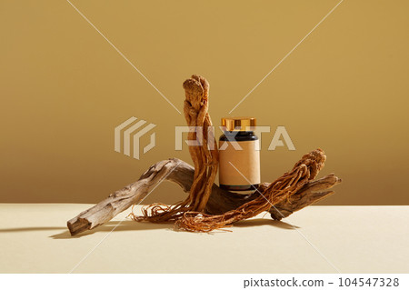 Angelica sinensis root (Dang Gui) display on a brown background with medicine bottle unbranded and dry twig.Space for design, advertising and branding product with herbal ingredient. Angelica sinensis root (Dang Gui) display on a brown background with medicine bottle unbranded and dry twig.Space for design, advertising and branding product with herbal ingredient. 104547328