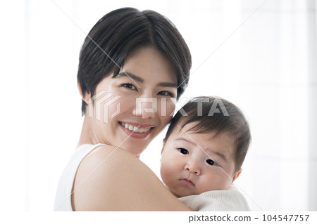 Lovely mother holding her baby looking at the camera 104547757