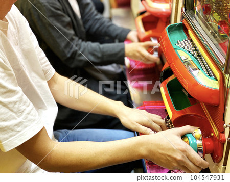 Hands of men and women who play pachinko side by side 104547931