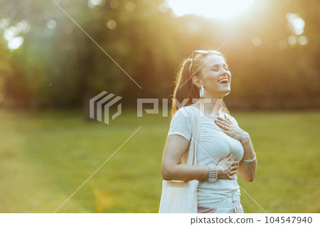 happy trendy woman in white shirt with hand on chest happy trendy woman in white shirt with hand on chest 104547940