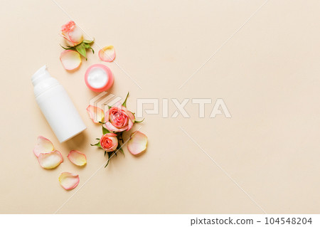 Fancy healthcare bottles for cream with rose flower. Natural oranic spa cosmetics concept. Mockup, template, Top view 104548204