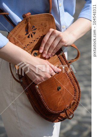 small light brown women's leather bag with a carved pattern. selective focus small light brown women's leather bag with a carved pattern. selective focus 104548311
