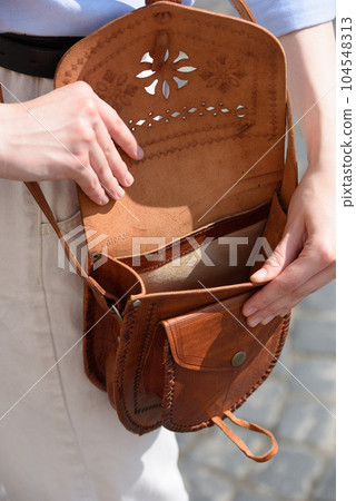 small light brown women's leather bag with a carved pattern. selective focus small light brown women's leather bag with a carved pattern. selective focus 104548313