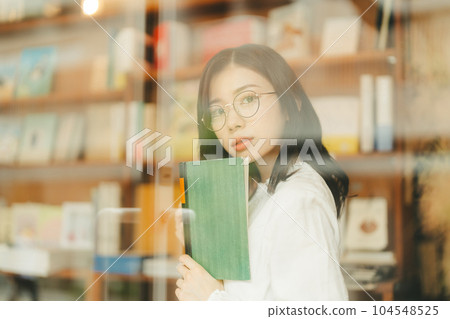 young woman in a bookstore young woman in a bookstore 104548525