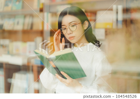 young woman in a bookstore young woman in a bookstore 104548526