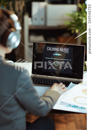 Seen from behind woman listening to music Seen from behind woman listening to music 104548783