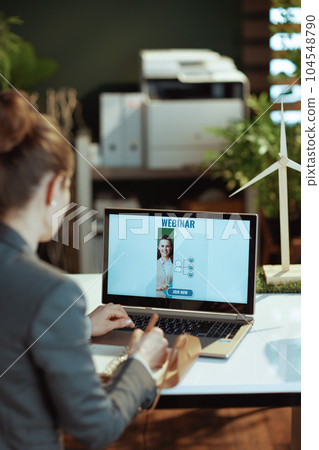 modern woman writes in notebook and having online webinar 104548790