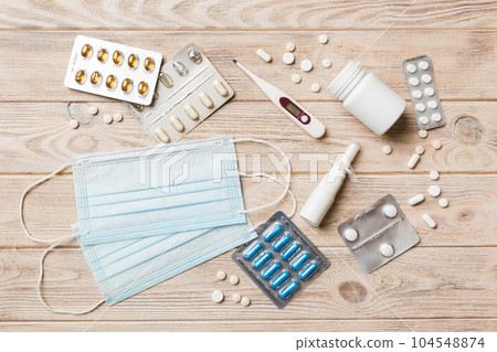 Protective face masks or surgical masks, medicine pills and thermometer on table background. Coronavirus disease. Corona virus concept. Space for text 104548874