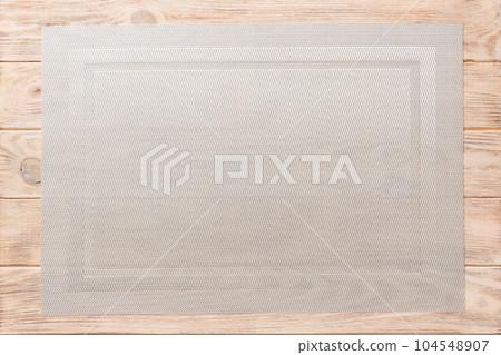 Top view of grey tablecloth for food on wooden background. Empty space for your design Top view of grey tablecloth for food on wooden background. Empty space for your design 104548907