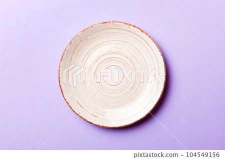 Top view of isolated of colored background empty round beige plate for food. Empty dish with space for your design 104549156