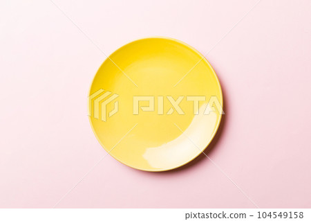 Top view of isolated of colored background empty round yellow plate for food. Empty dish with space for your design 104549158