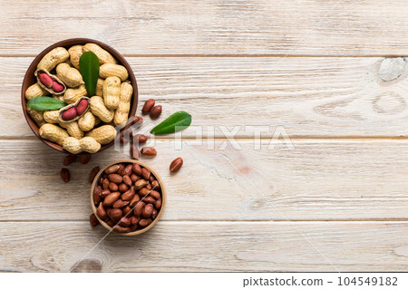 Fresh healthy peanuts in bowl on colored table background. Top view Healthy eating bertholletia concept. Super foods 104549182
