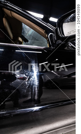 Before and after effect after paint polishing, varnish correction in car detailing studio or car wash 104549899