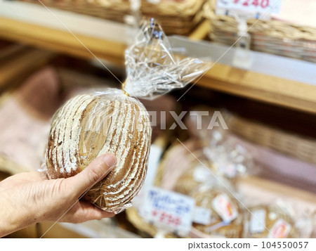 Woman's hand choosing bread in a plastic bag Woman's hand choosing bread in a plastic bag 104550057