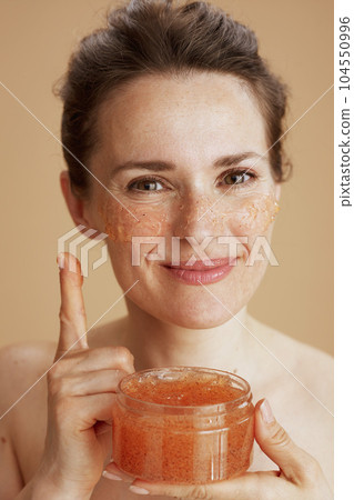 smiling young female with face scrub 104550996