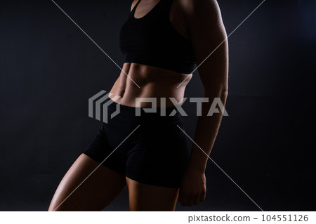 Fitness woman showing abs and flat belly, isolated. Athletic female shaped abdominal Fitness woman showing abs and flat belly, isolated. Athletic female shaped abdominal 104551126