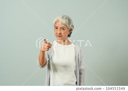 Image of strict mature woman pointing finger at camera isolated on blue color background Image of strict mature woman pointing finger at camera isolated on blue color background 104551549