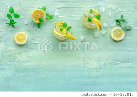 Lemonade with mint. Lemon water drink with ice. Two glasses and lemons Lemonade with mint. Lemon water drink with ice. Two glasses and lemons 104552013
