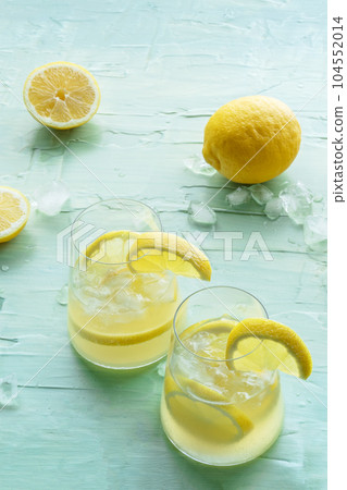Lemonade. Lemon water drink with ice. Two glasses and fruits on blue Lemonade. Lemon water drink with ice. Two glasses and fruits on blue 104552014
