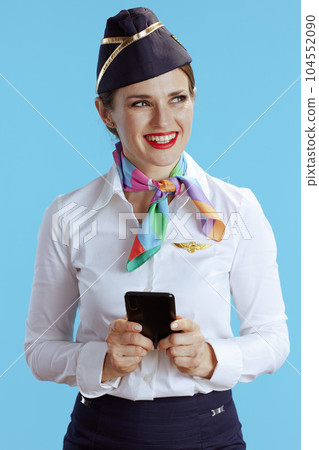 happy stylish female stewardess on blue using phone 104552090