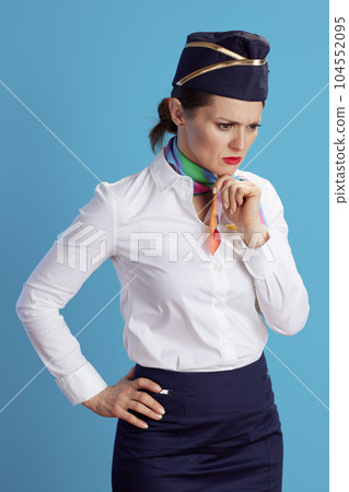 pensive elegant female air hostess on blue pensive elegant female air hostess on blue 104552095