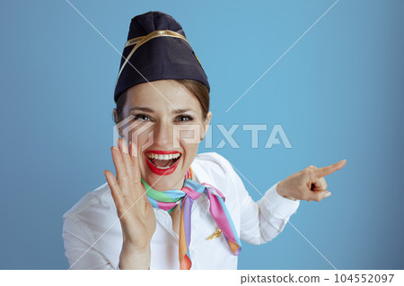 female flight attendant on blue announcing good news pointing 104552097