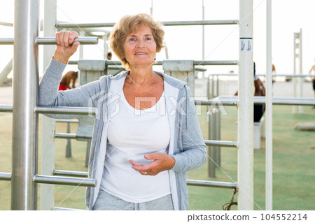 Old lady in outdoor workout station 104552214