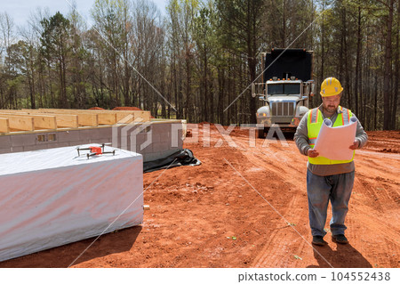 As an experienced builder engineer will be able to hold blueprints in his hands monitor construction progress while on construction site As an experienced builder engineer will be able to hold blueprints in his hands monitor construction progress while on construction site 104552438