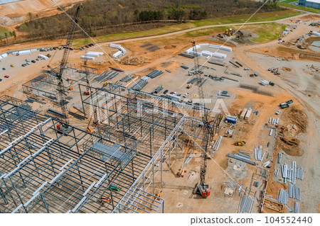 Cranes that are used to construct metal steel framing beams of steel for construction an industrial building Cranes that are used to construct metal steel framing beams of steel for construction an industrial building 104552440