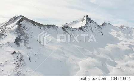 Panoramic view of snowy mountains at alpine ski resort in Livigno, Italy. Snow mountain range landscape on winter day.  104553305