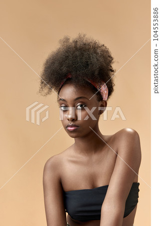 Tenderness. Portrait of young, beautiful, african woman with well-kept, health skin posing in top against studio background 104553886