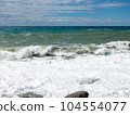 Mediterranean Sea waves crashing over rocks on a beach in stormy weather 104554077