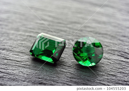 natural green emerald sapphire precious gemstone on stone background 104555203