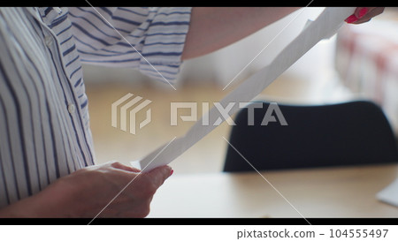 Close-up woman hands pull out paper envelope utility bill paper letter bank documents. Woman hands opening paper letter post invoice tax forms. Close-up woman hands pull out paper envelope utility bill paper letter bank documents. Woman hands opening paper letter post invoice tax forms. 104555497