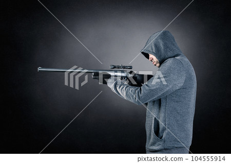 Hooded man with rifle over dark misty background Hooded man with rifle over dark misty background 104555914