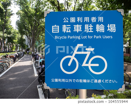 Information board indicating bicycle parking lot for park users and bicycles placed in the parking lot Information board indicating bicycle parking lot for park users and bicycles placed in the parking lot 104555944