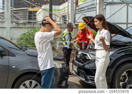 An unset young woman talking angryly to a man who accidentally drove his car and hit her car An unset young woman talking angryly to a man who accidentally drove his car and hit her car 104555970