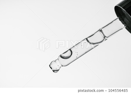 Transparent pipette with cosmetics on a white isolated background. Transparent pipette with cosmetics on a white isolated background. 104556485